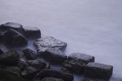 Rocks in sea against sky