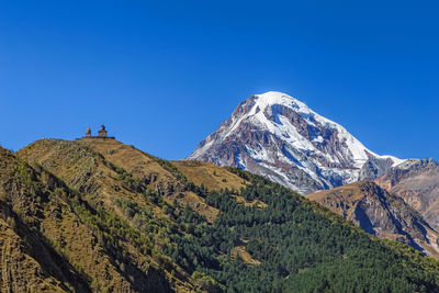 Scenic view of mountains against clear blue sky