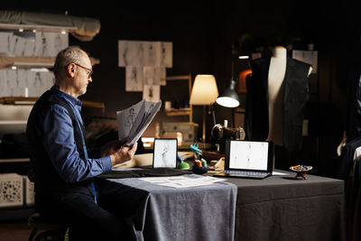 Midsection of man using mobile phone while sitting at home