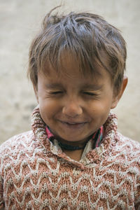 Close-up of smiling boy with eyes closed wearing warm clothing outdoors