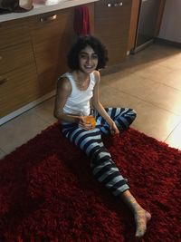 Portrait of smiling girl sitting on floor at home