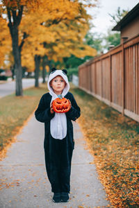 Portrait of girl standing on autumn leaves