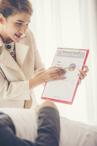 Businesswoman pointing at graph on clipboard