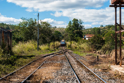 Railroad tracks amidst trees against sky