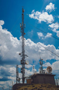 Low angle view of communications tower against blue sky