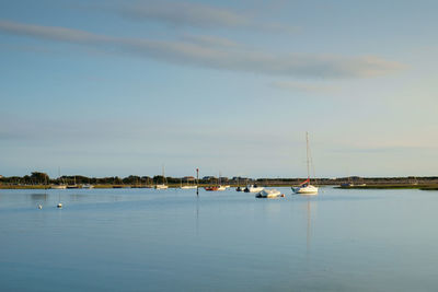 Sailboats in sea against sky