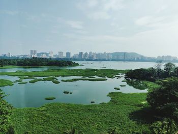 Scenic view of lake and buildings against sky