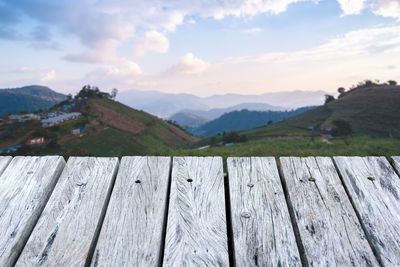 Wooden fence on mountains against sky