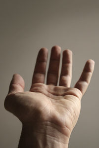 Cropped hand against beige background