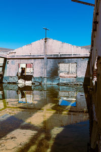 View of abandoned building against clear blue sky