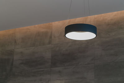 Low angle view of illuminated pendant light hanging from ceiling