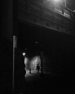 Full length of woman in illuminated dark room