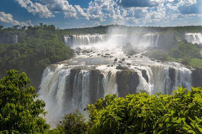 Scenic view of waterfall against sky