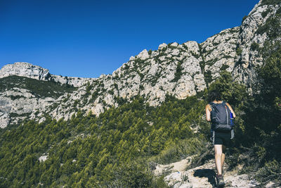 Woman hiking on a mountain path in catalonia on a cloudy summer day