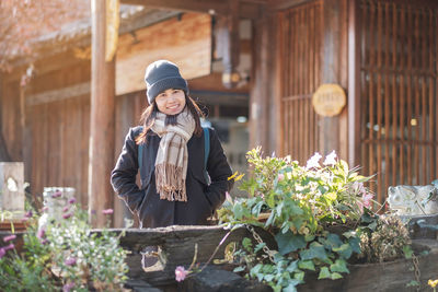 Full length of woman standing by flowering plants