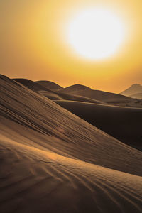 Scenic view of desert against sky during sunset