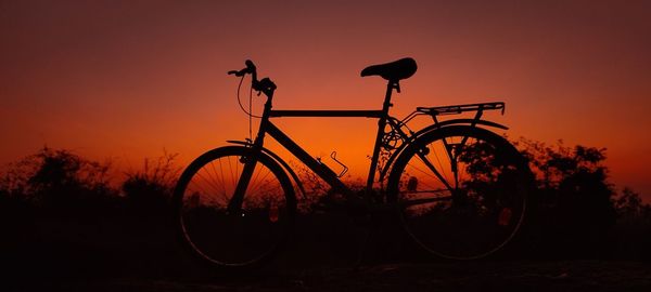 Low angle view of bicycle against sky during sunset