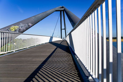 Footbridge against clear blue sky