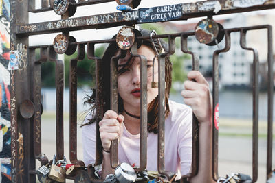 Portrait of woman looking through railing