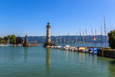 View of marina at harbor against blue sky