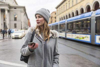 Full length of young woman standing on train at winter