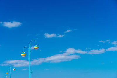 Low angle view of street lights against blue sky