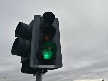 Low angle view of road signal against sky