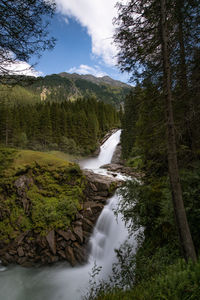 Scenic view of krimm waterfall in forest against sky