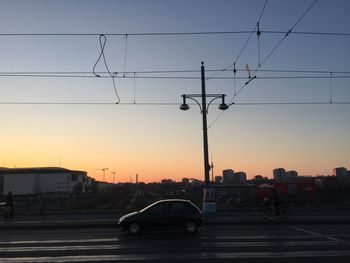 Car on bridge against sky during sunset