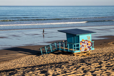 Lifeguard hut on beach against sky