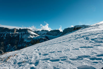 Scenic view of snowcapped mountains against blue sky