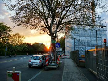 Cars on road against sky during sunset