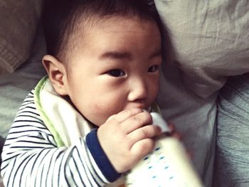 Portrait of cute baby boy drinking milk from bottle