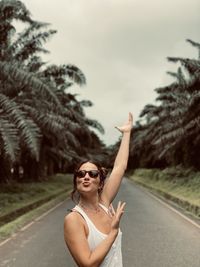 Portrait of woman with sunglasses on road against sky