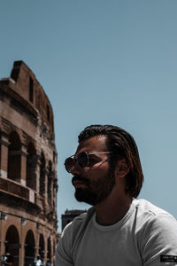 Low angle view of man standing against clear sky