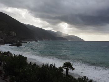 Scenic view of sea and mountains against sky