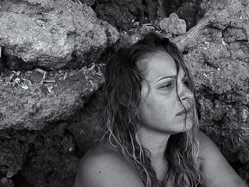 Thoughtful woman against rock