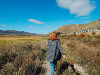 Rear view of young woman walking on land