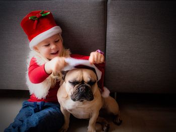 Child playing with dog at christmas