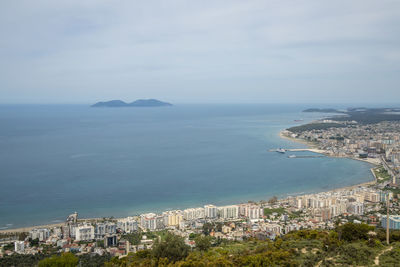 High angle view of townscape by sea against sky