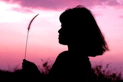 Nature and beauty concept. pink and orange sundown. girl silhouette at sunset