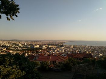 High angle view of townscape by sea against clear sky