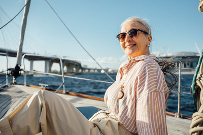 Woman standing on boat in sea against sky