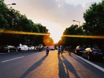 People on street against sky during sunset