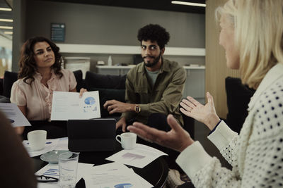 Group of business people analyzing charts during meeting in lobby