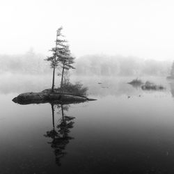 Scenic view of lake against sky during foggy weather