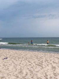 People on beach against sky