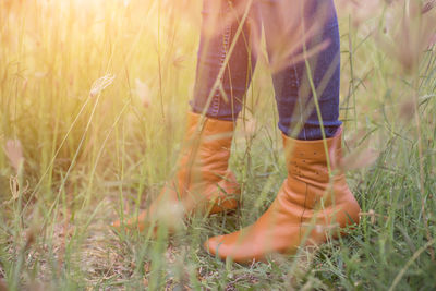 Low section of woman standing on field