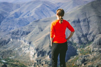 Rear view of woman standing against mountains