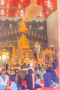 Group of people in illuminated temple outside building